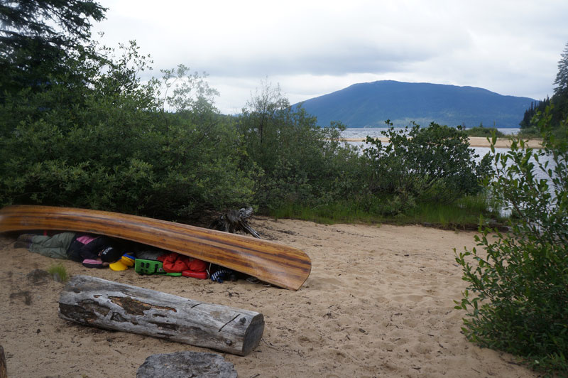 Hunkered down under the canoes.